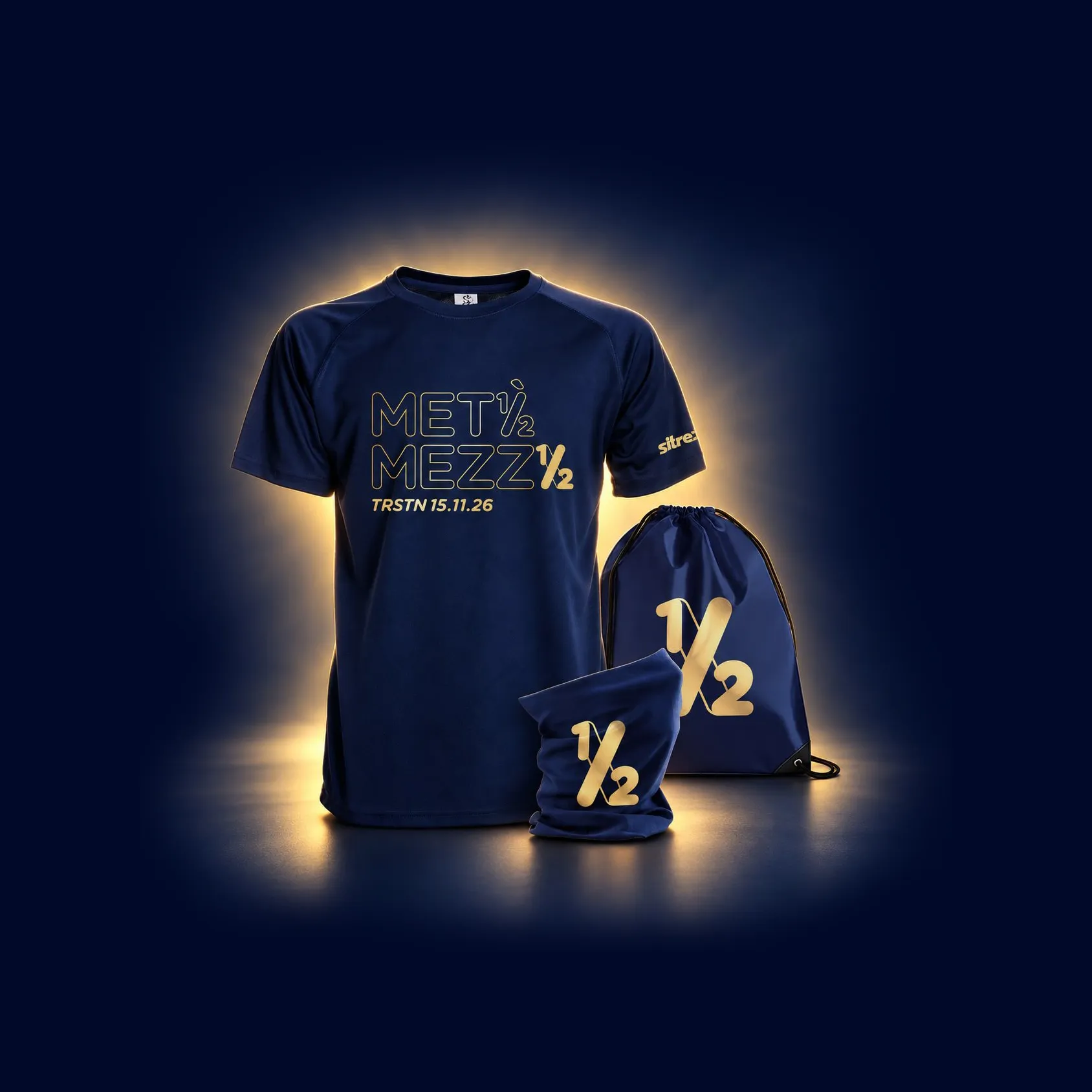 Il pacco gara: maglia tecnica blu con la scritta MetàMezza TRSTN 15.11.26 in oro, scaldacollo e sacca con il logo ½
